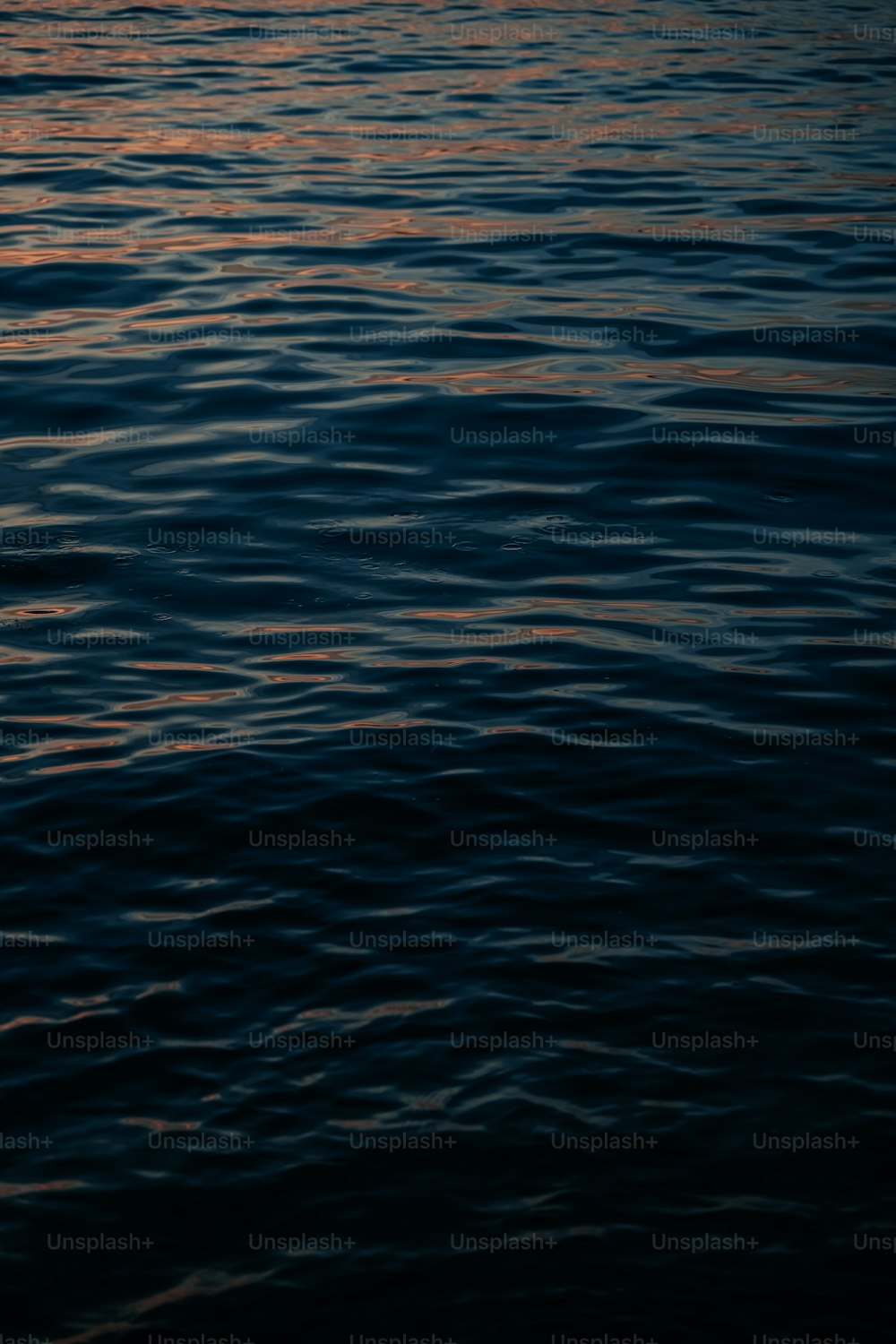 a large body of water with a boat in the distance