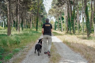 未舗装の道路を犬を散歩させる男