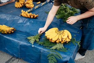 a man reaching for a bunch of bananas on a table