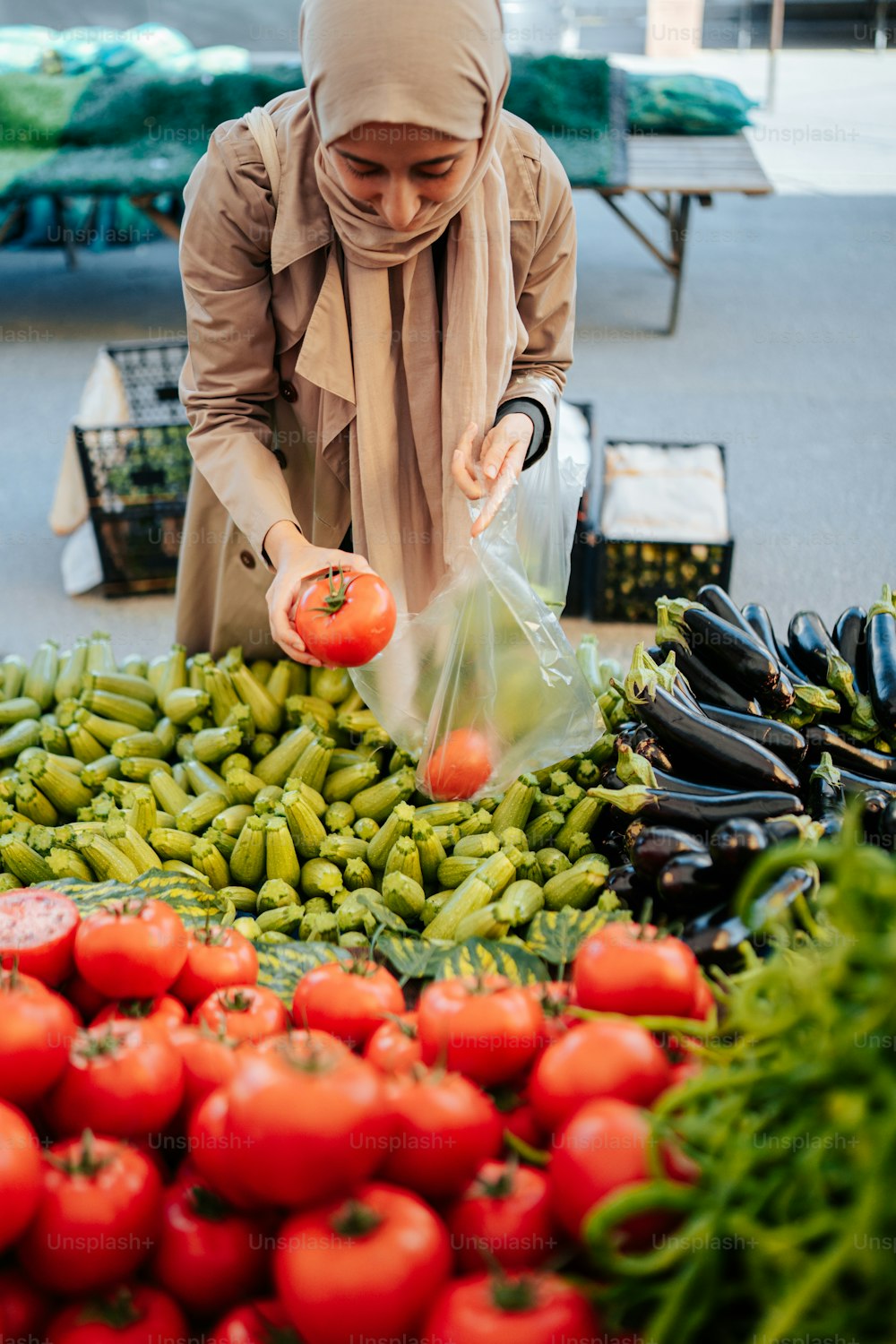 히잡을 쓴 여자가 야채를 쇼핑하고 있다