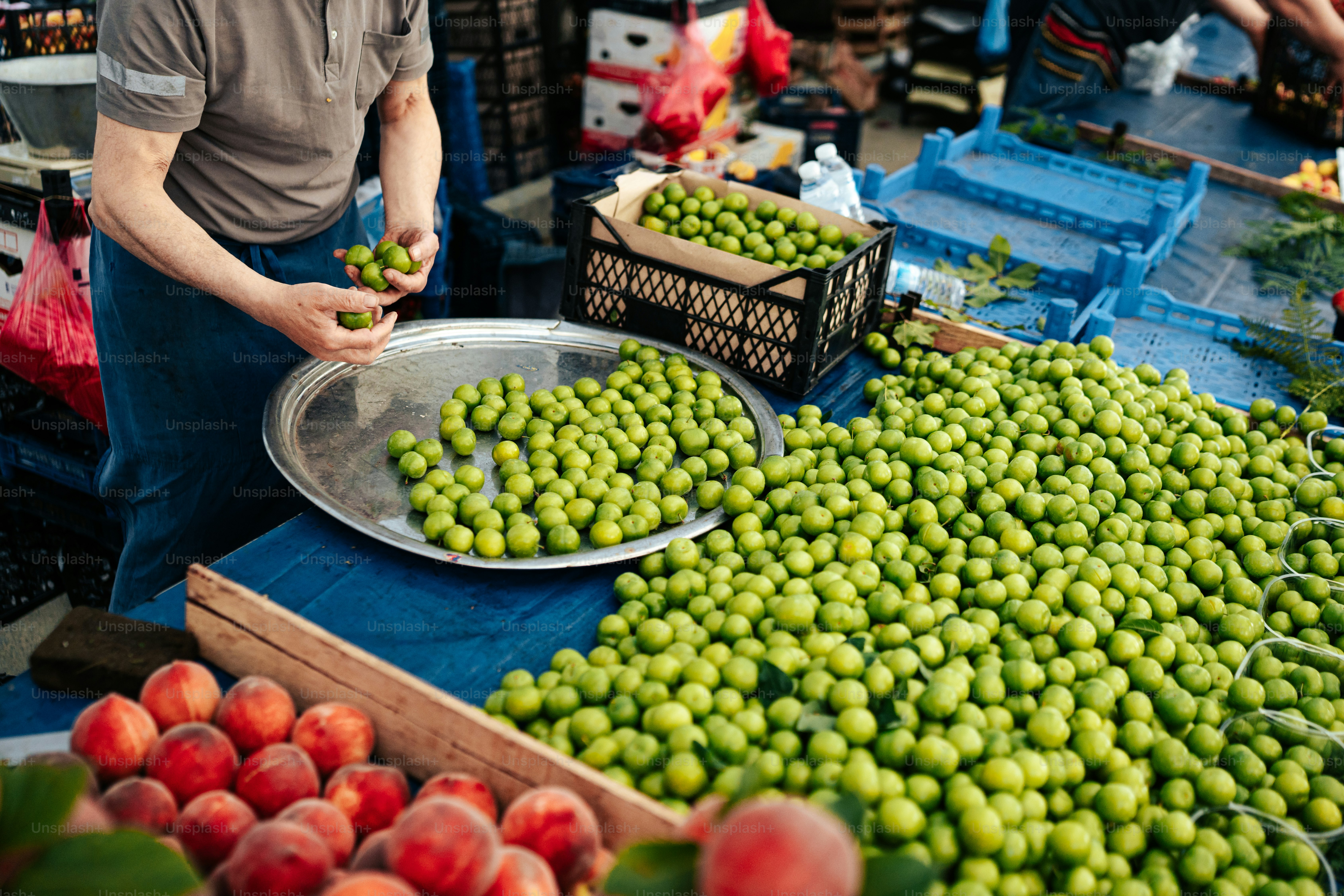 Un uomo in piedi davanti a un tavolo pieno di frutta