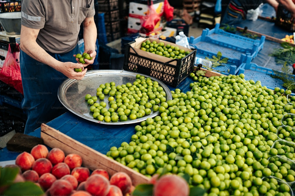 a man standing in front of a table filled with fruit