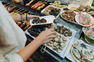 a woman standing in front of a table filled with food