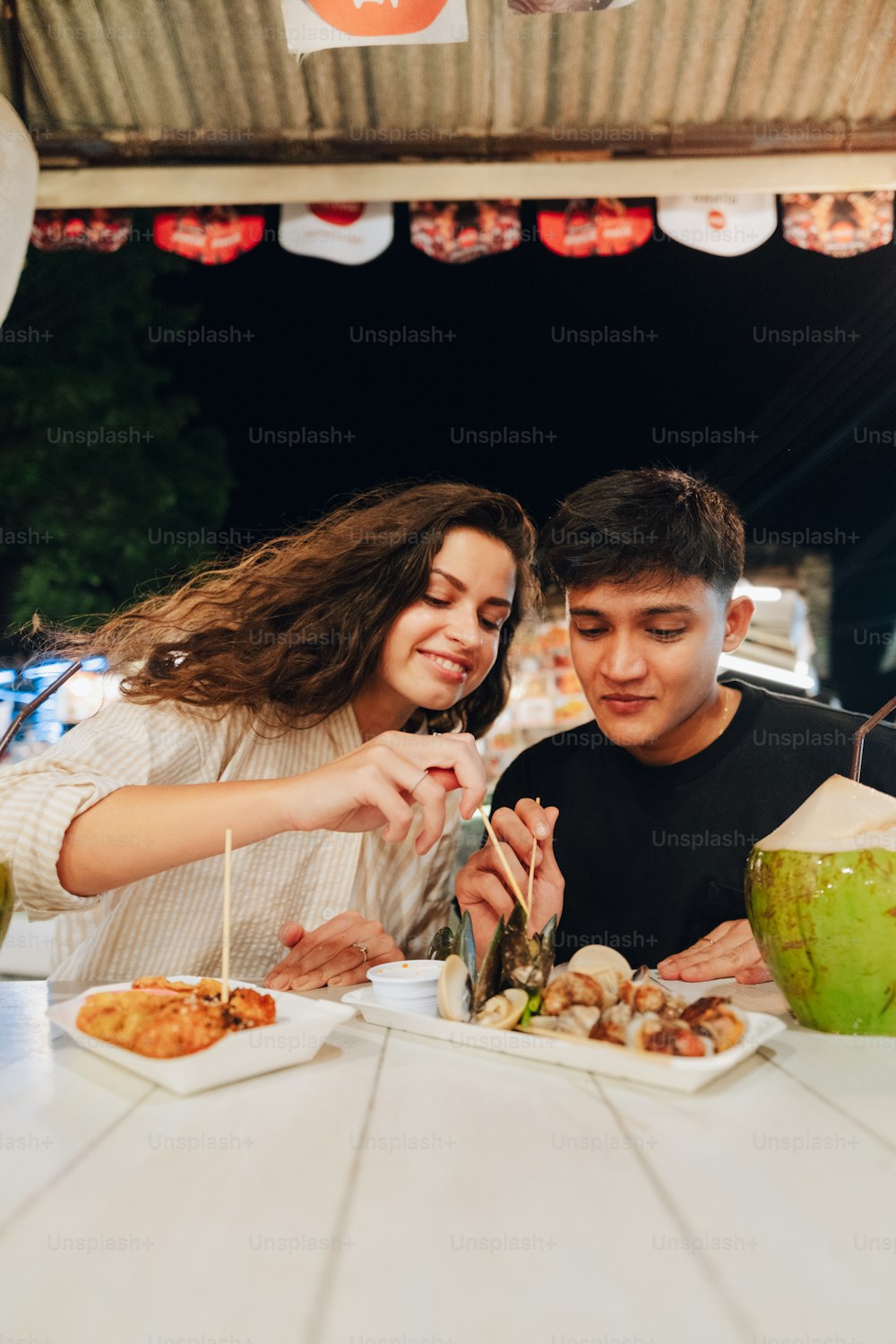 a man and a woman sitting at a table eating food