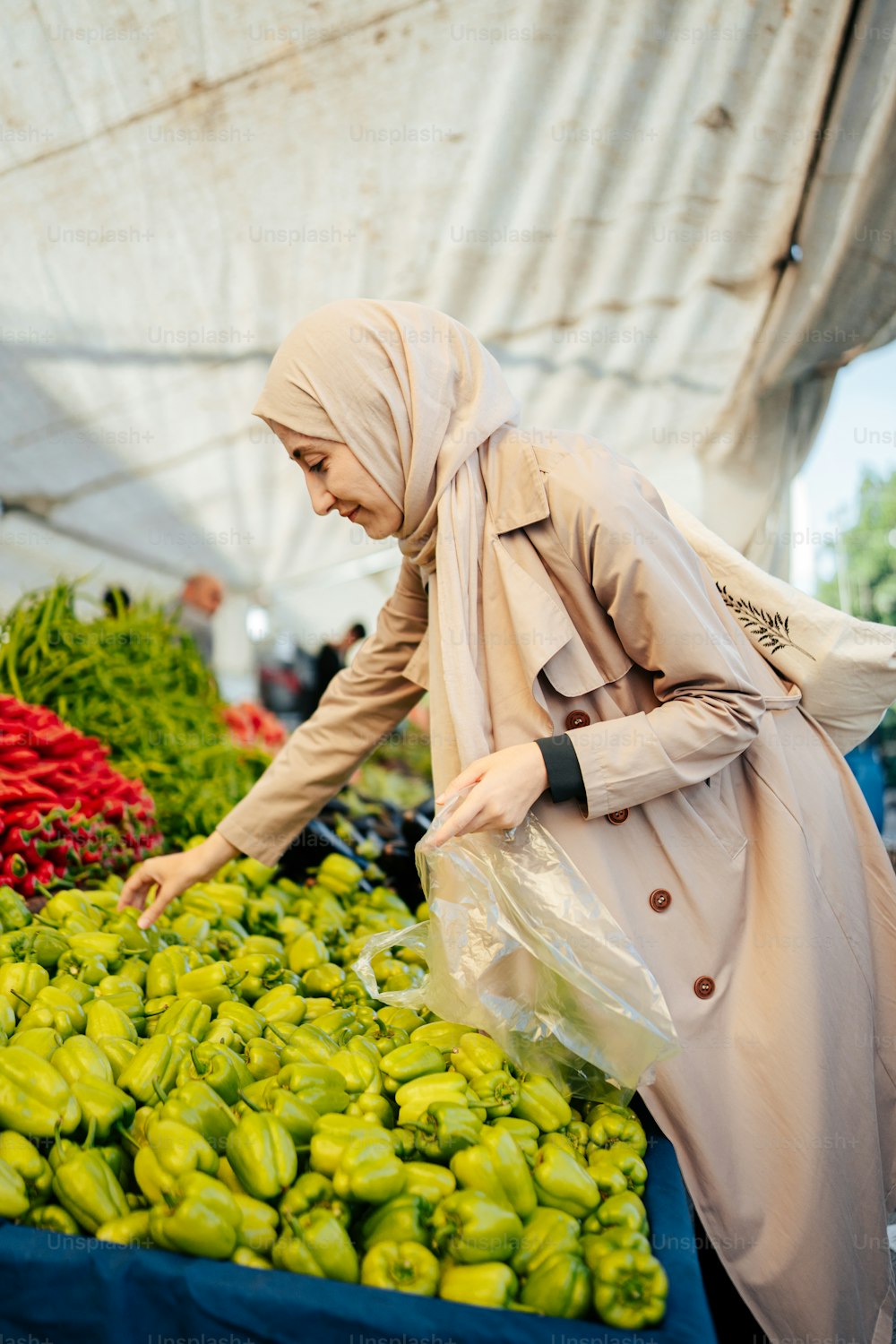 Una donna in un hijab che acquista verdure