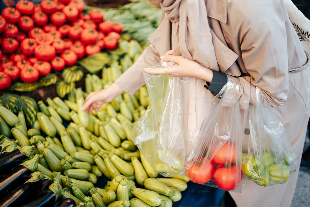 uma mulher em pé em frente a uma exposição de legumes