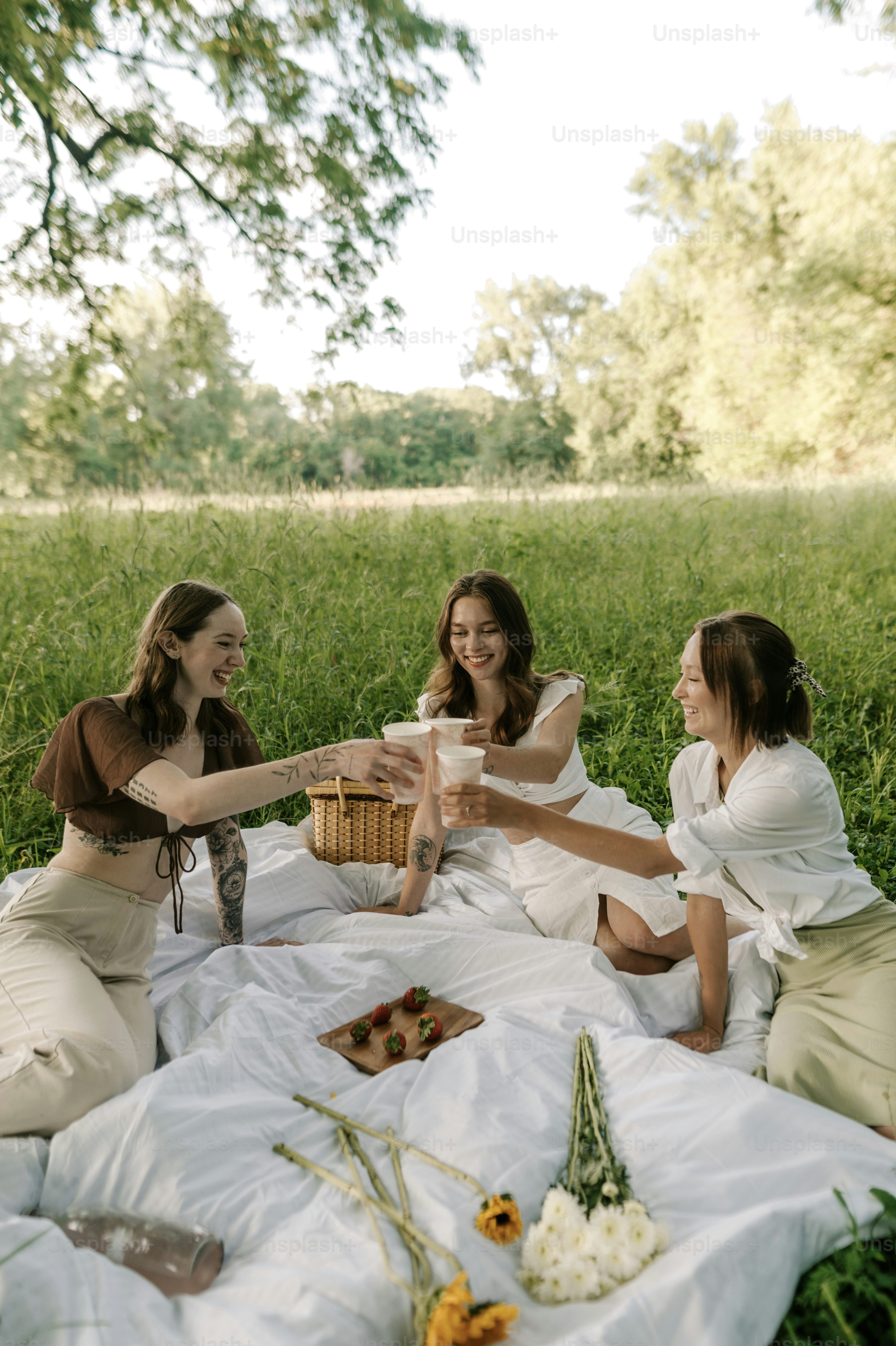 a group of women sitting on top of a lush green field
