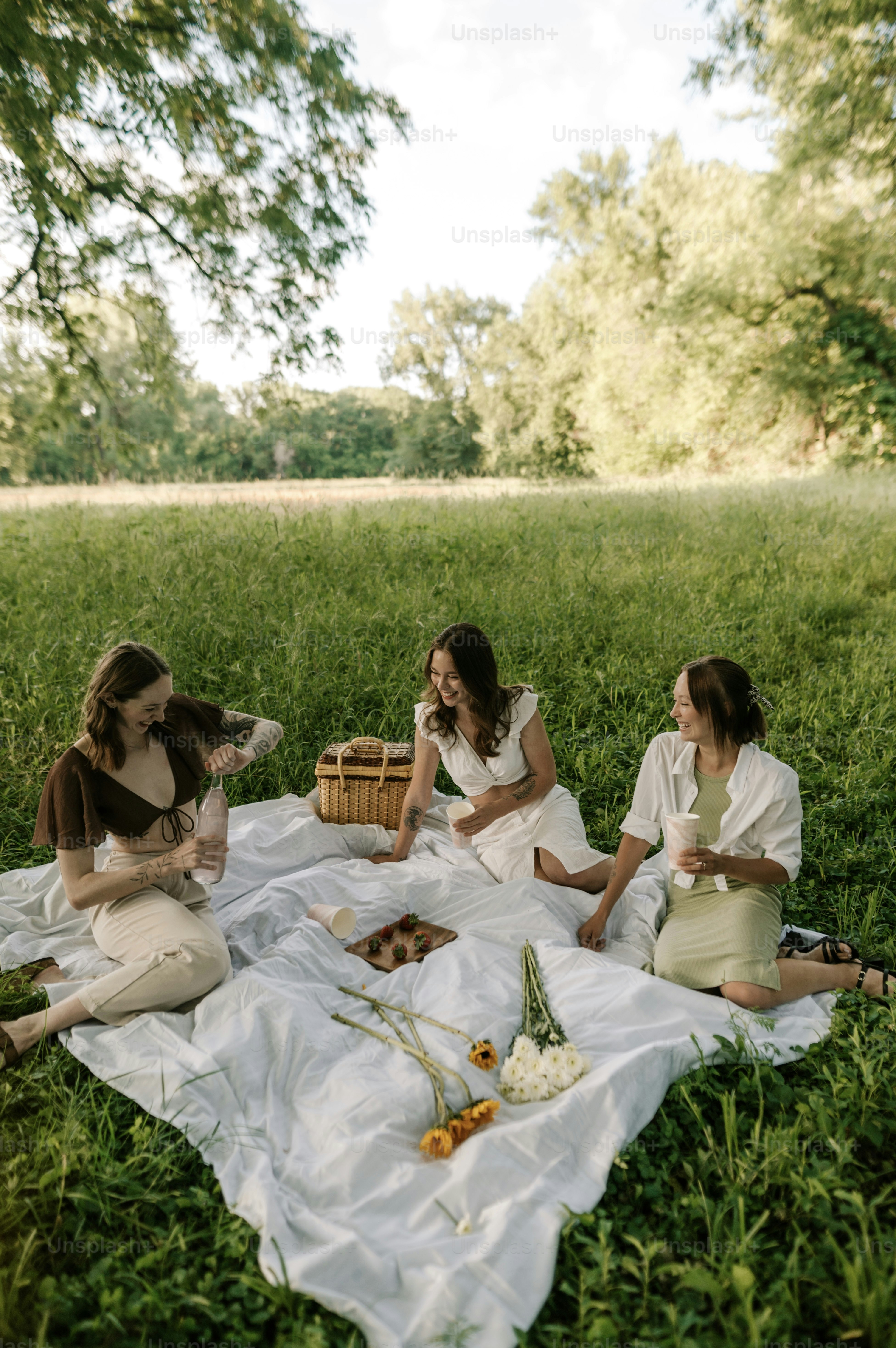 a group of women sitting on top of a lush green field