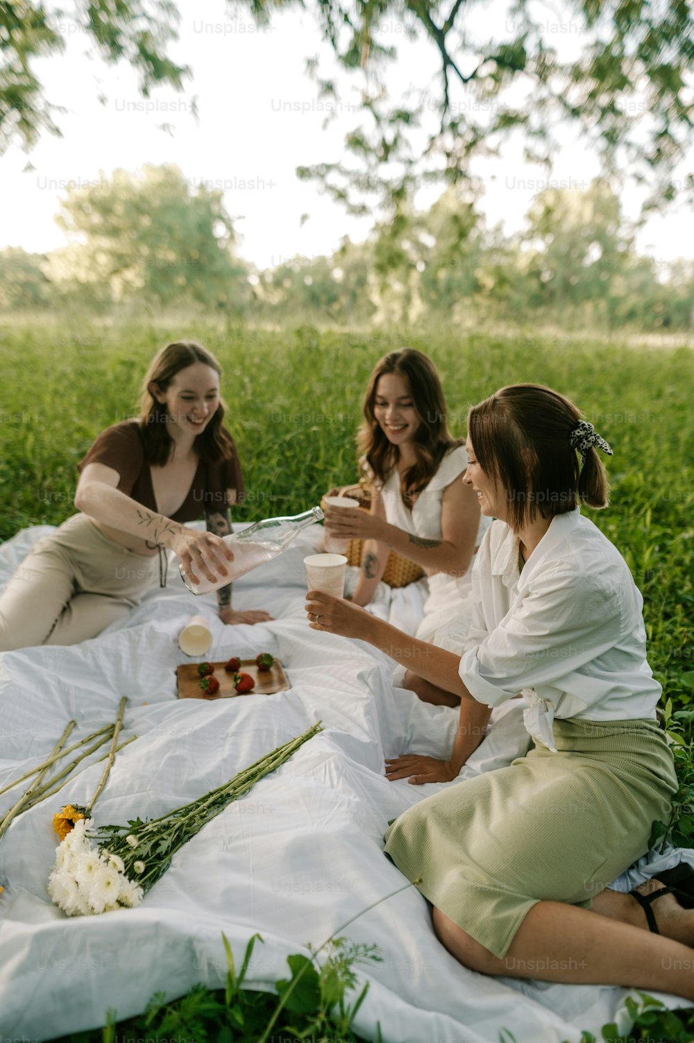 Un groupe de femmes assises au sommet d’un champ couvert d’herbe