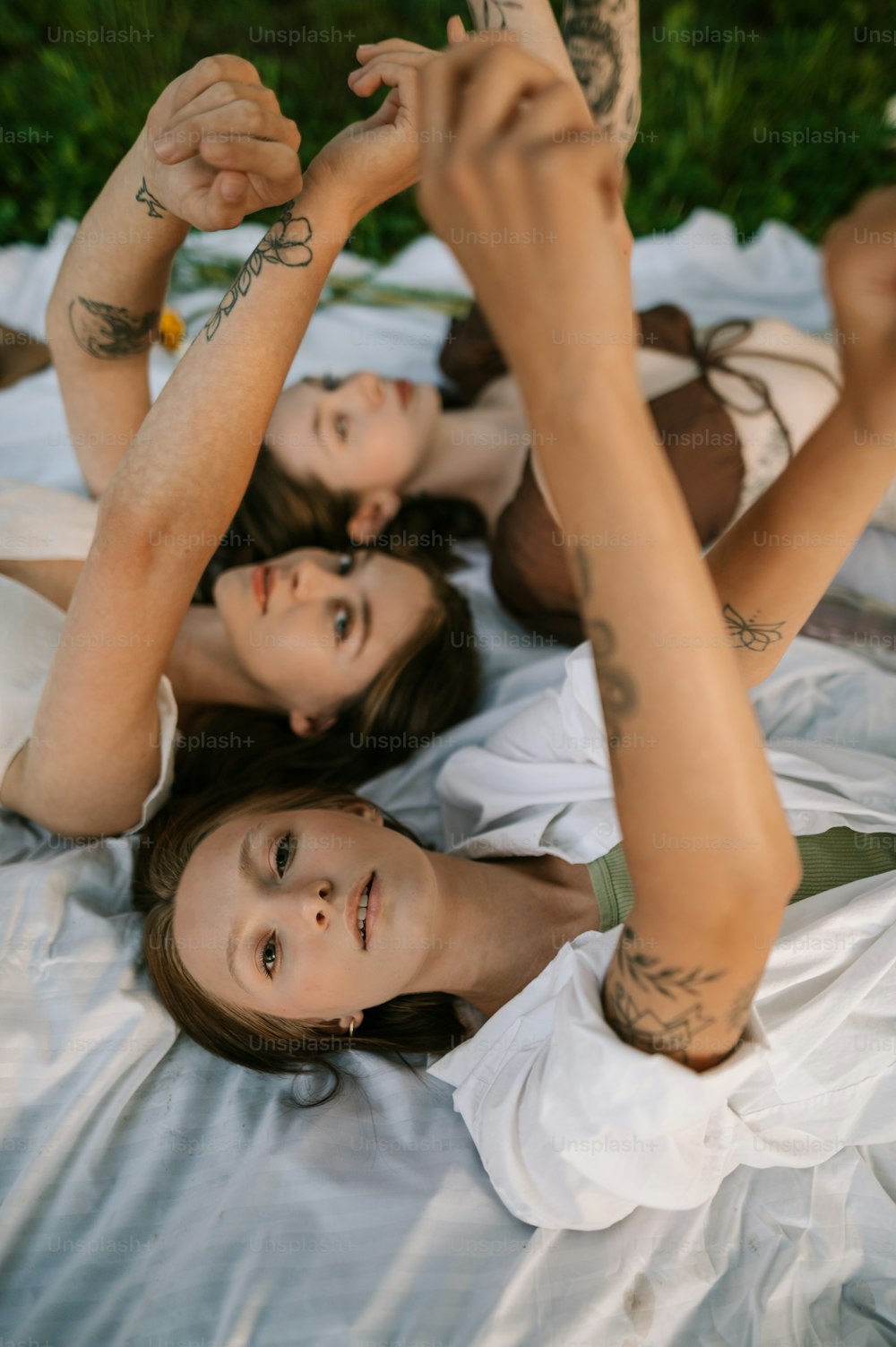 um grupo de mulheres deitadas em cima de um lençol branco