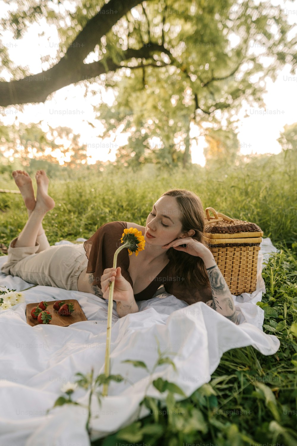 a woman laying on a blanket in a field