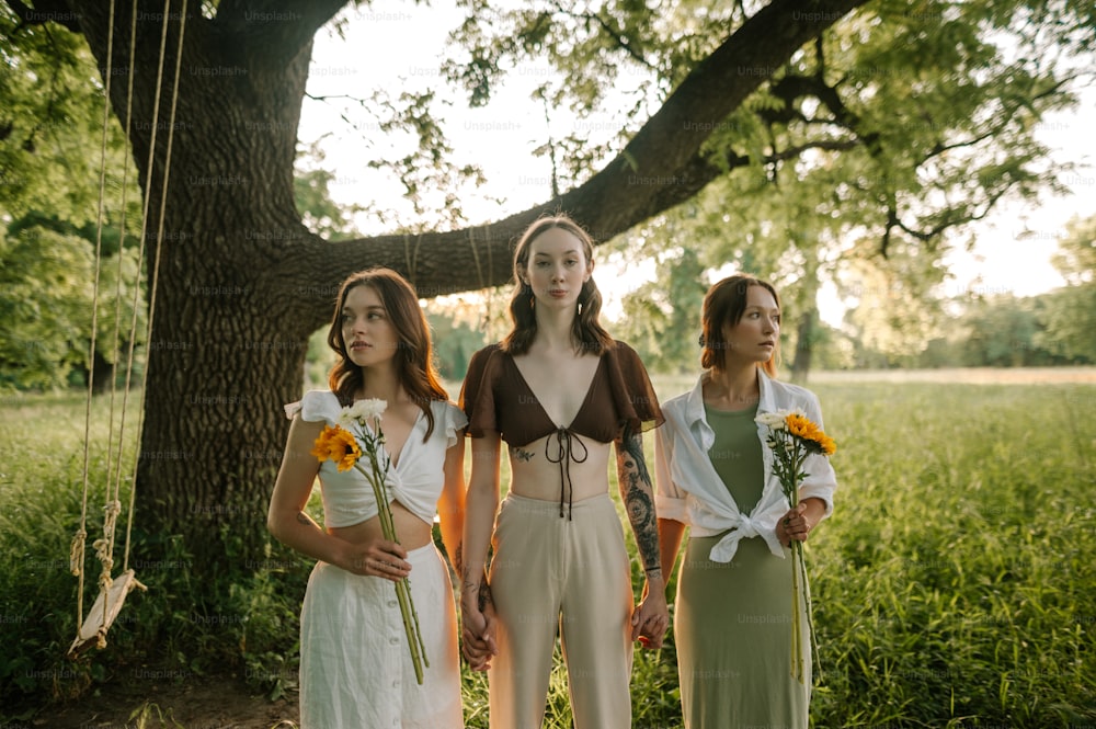 a group of women standing next to each other under a tree