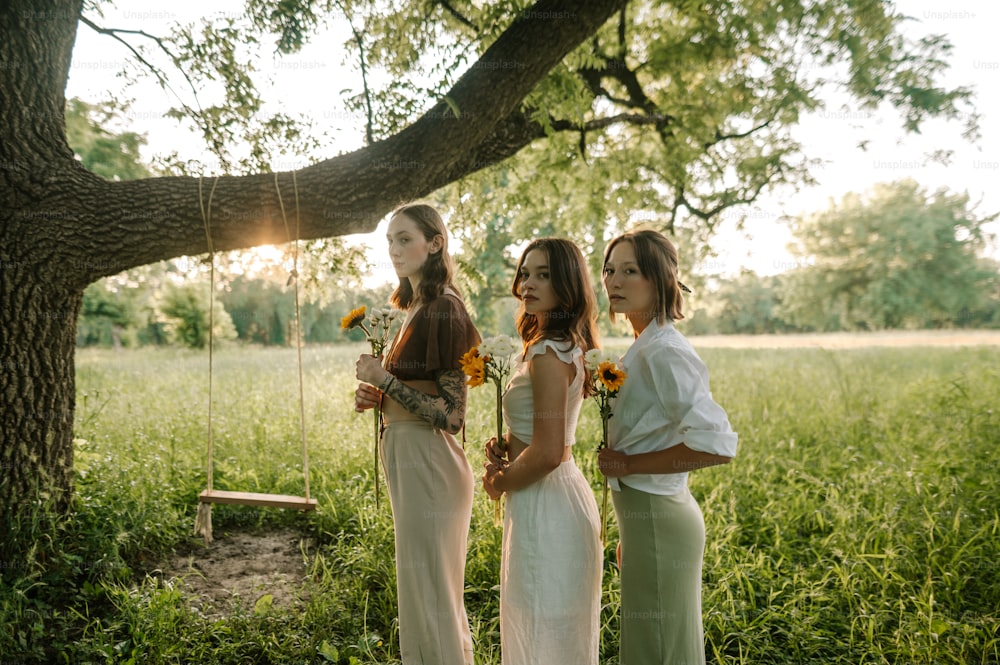 a group of women standing next to each other under a tree