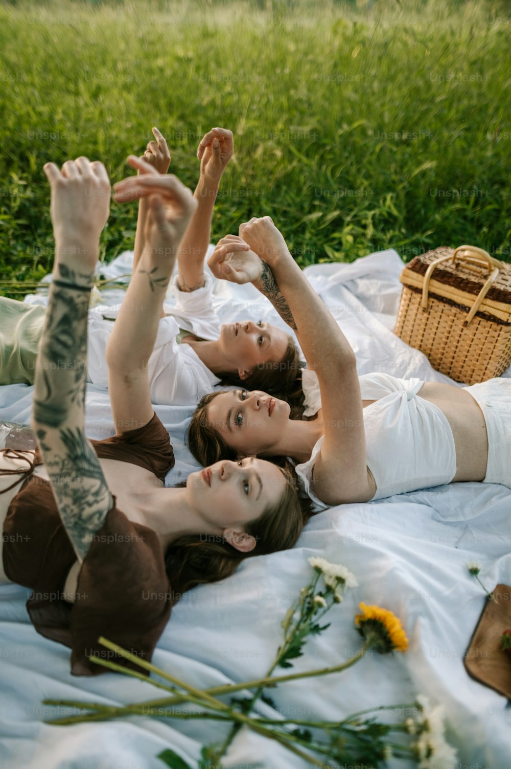 a couple of women laying on top of a blanket