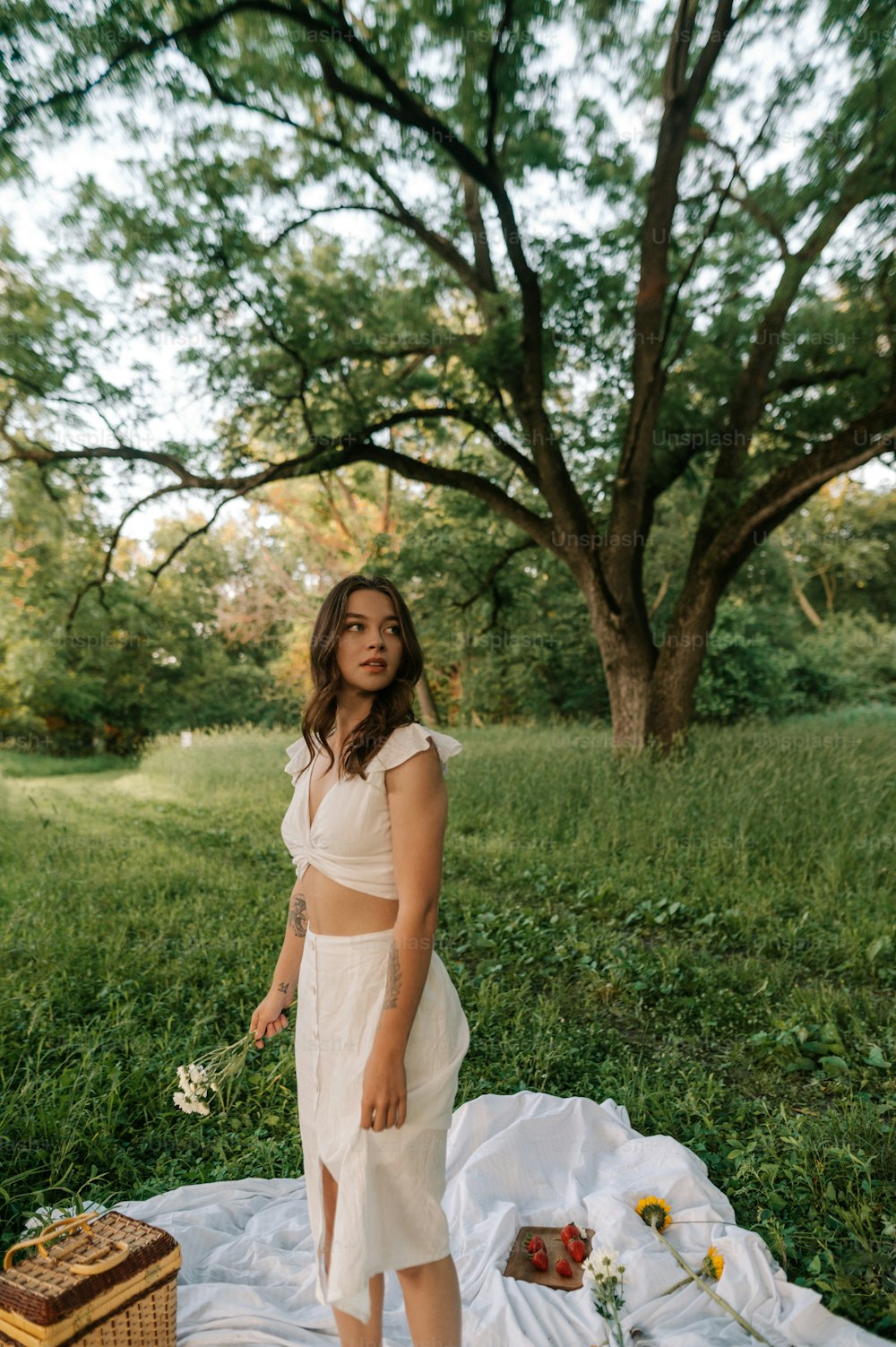 a woman standing on a blanket in a field