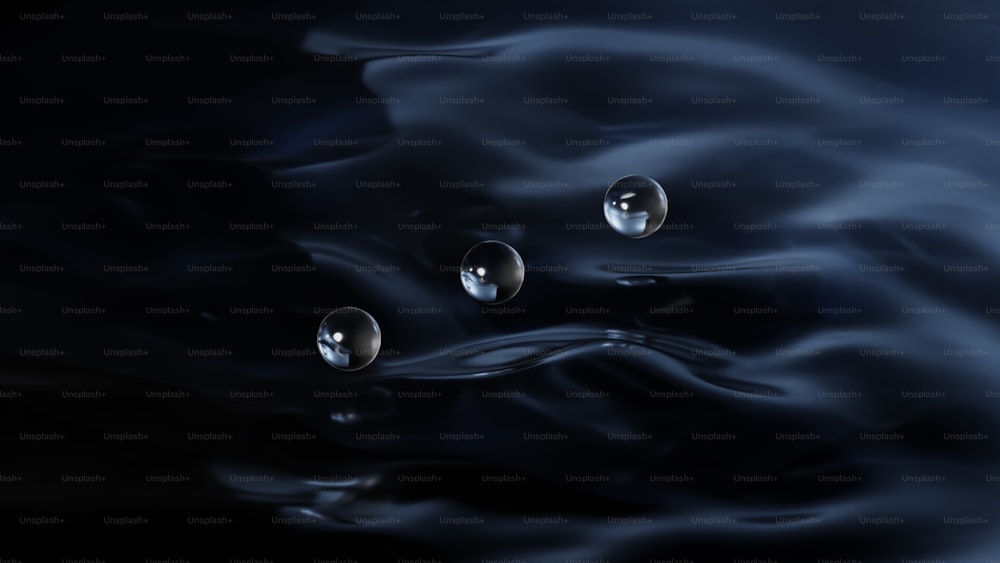 a group of water droplets floating on top of a black surface