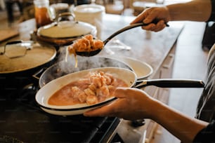 a person stirring food in a bowl on a stove