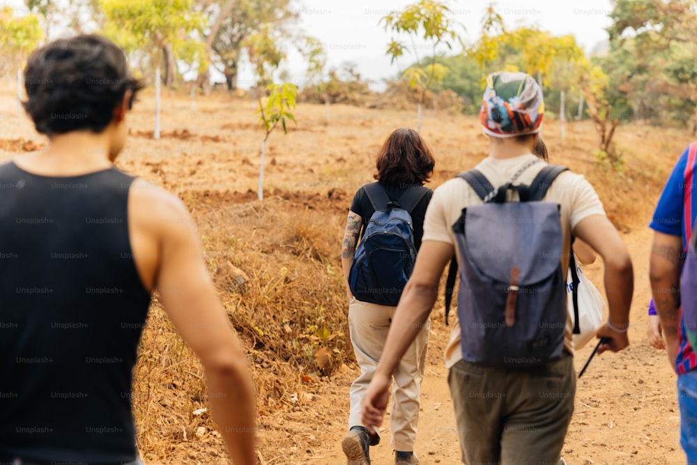 a group of people walking down a dirt road