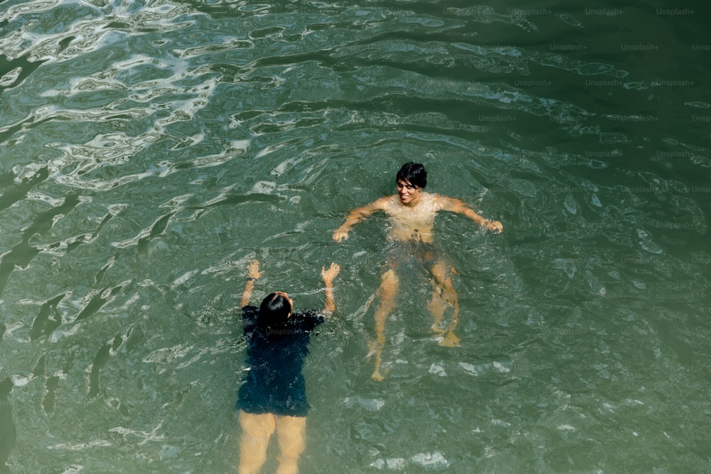 um homem e uma mulher nadando em um corpo de água
