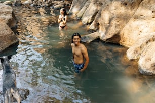 a man standing in a pool of water next to a dog