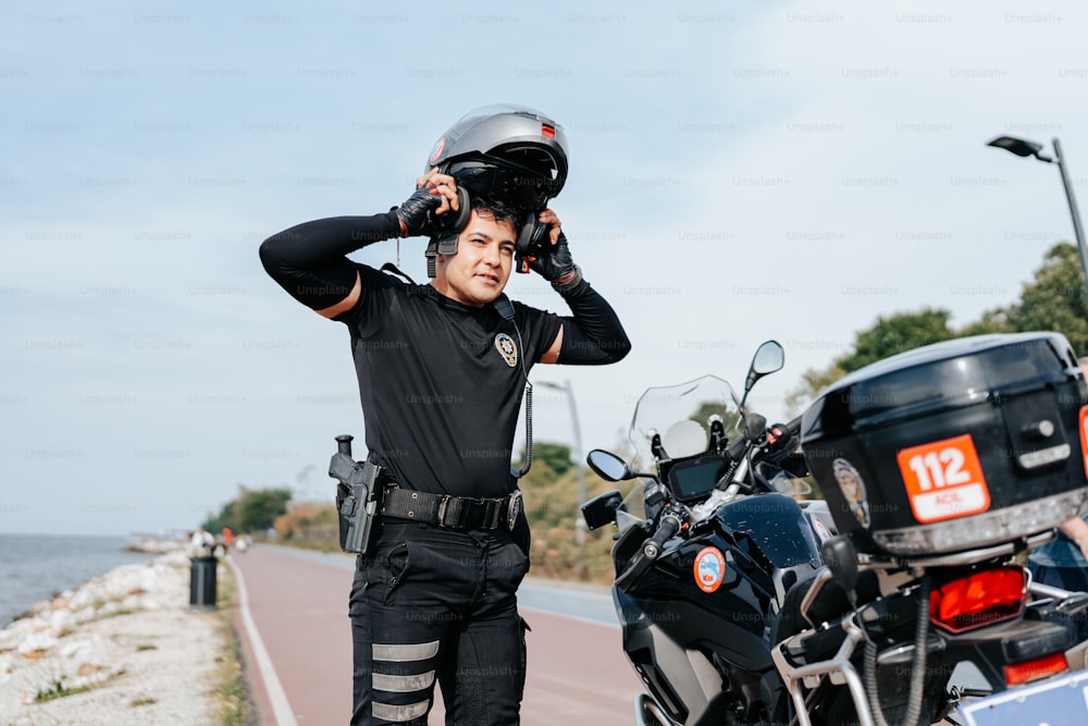 ヘルメットをかぶったバイクの隣に立っている男性