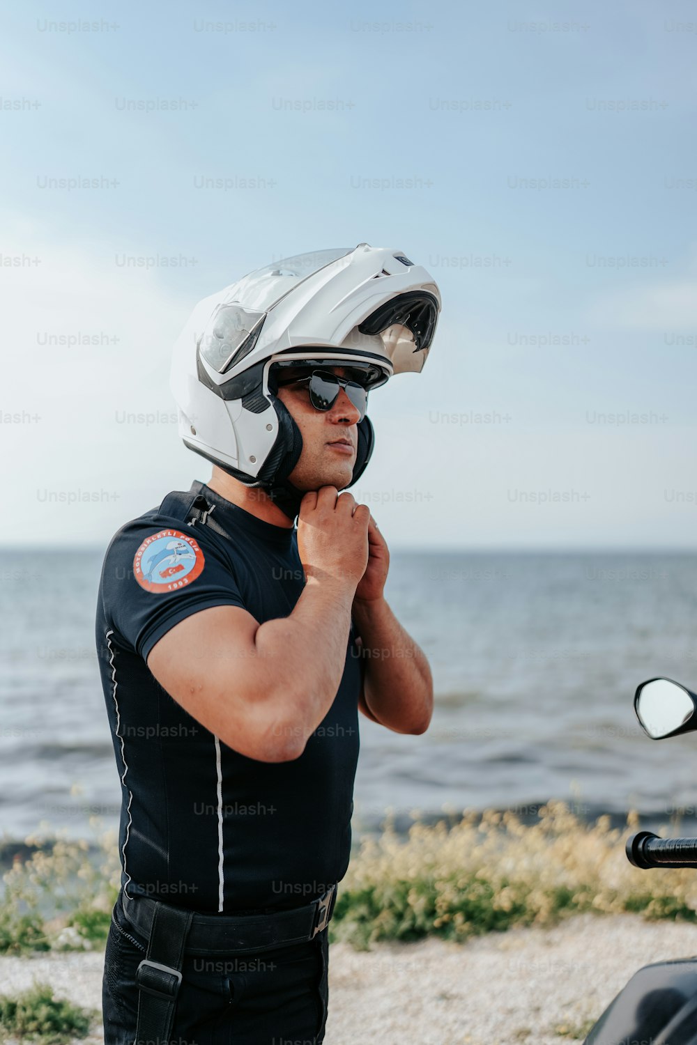 バイクの横に立つヘルメットをかぶった男