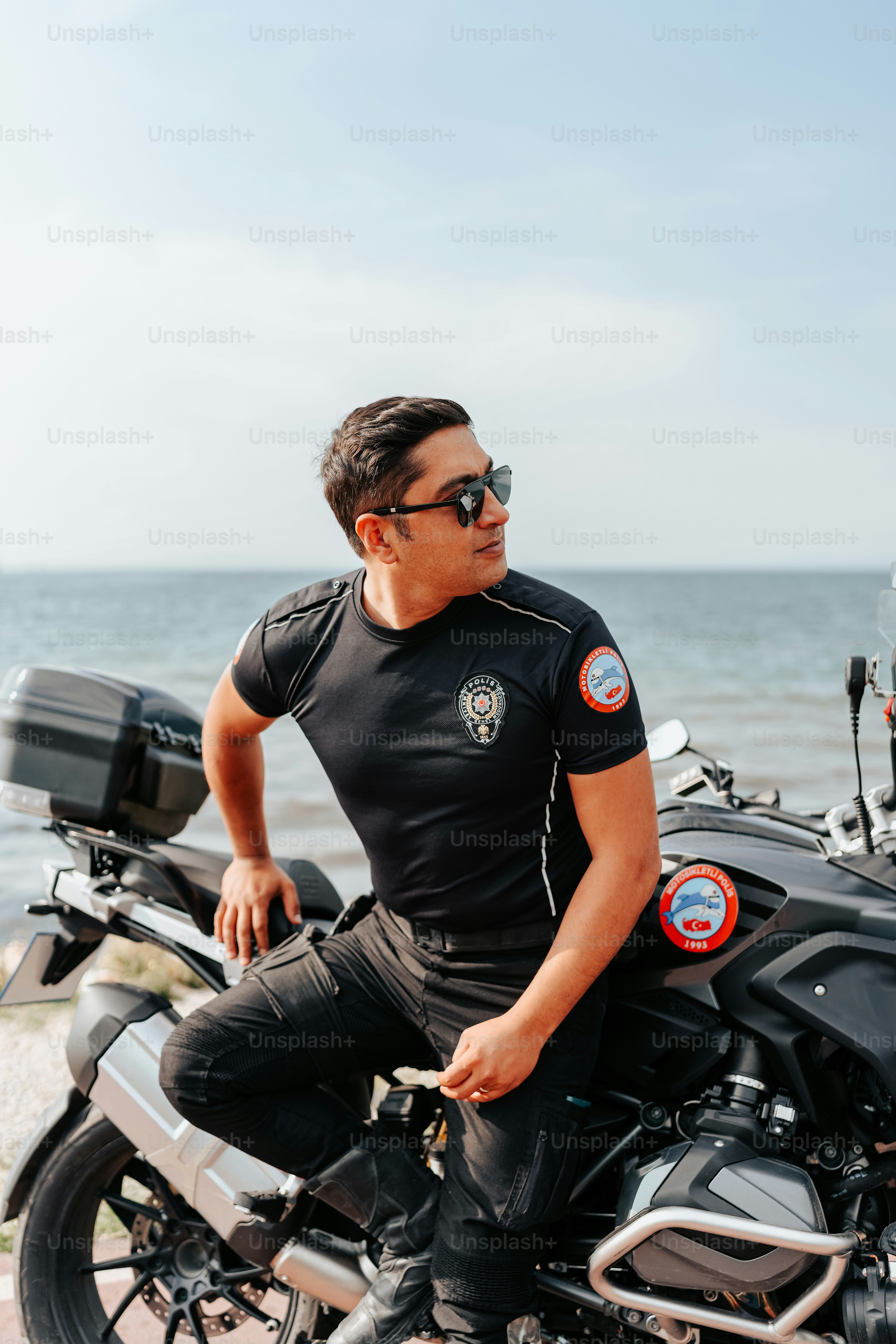 a man sitting on a motorcycle on the beach