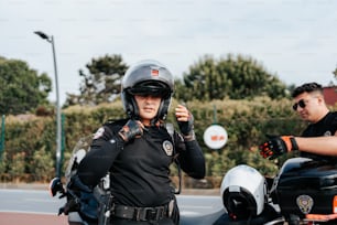 Un hombre con uniforme de policía parado junto a una motocicleta