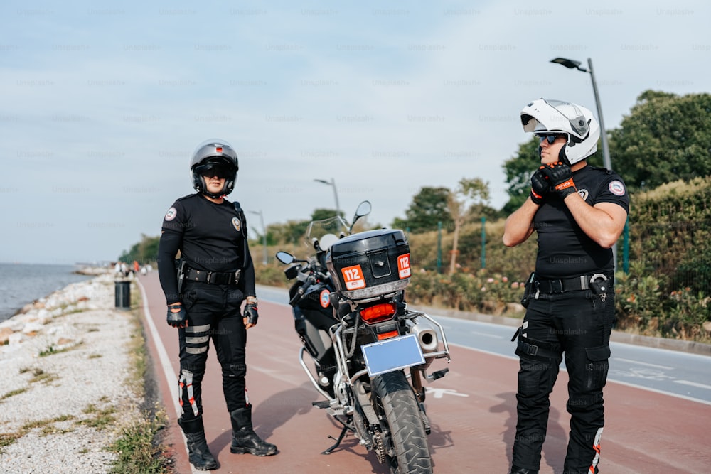 two police officers standing next to a motorcycle