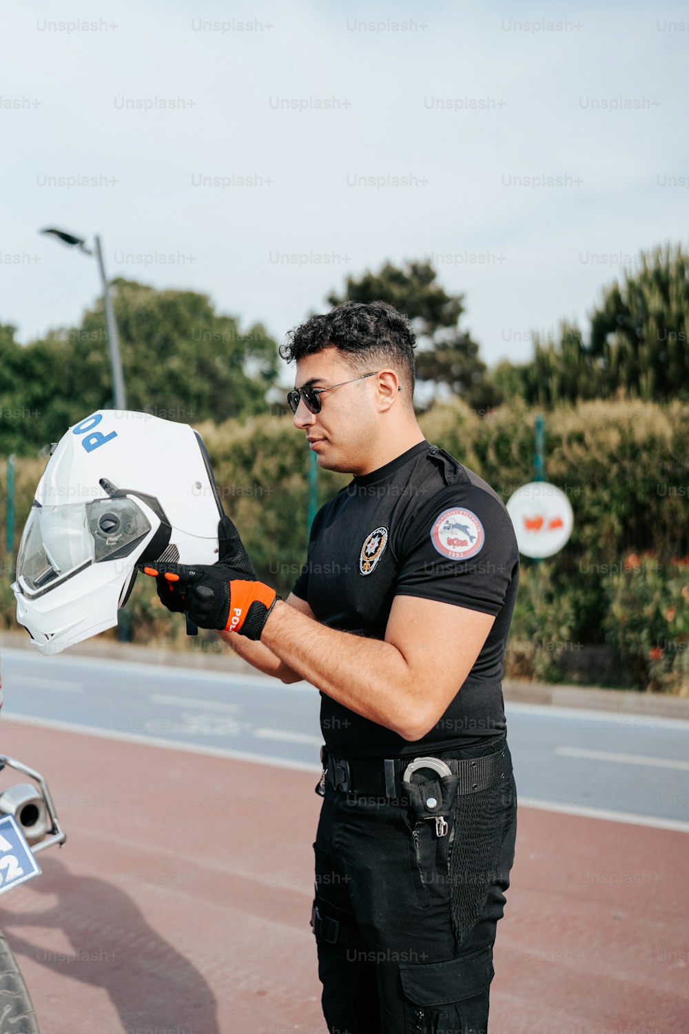 a man wearing a helmet and holding a motorcycle helmet