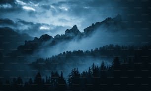 a mountain range covered in fog and clouds