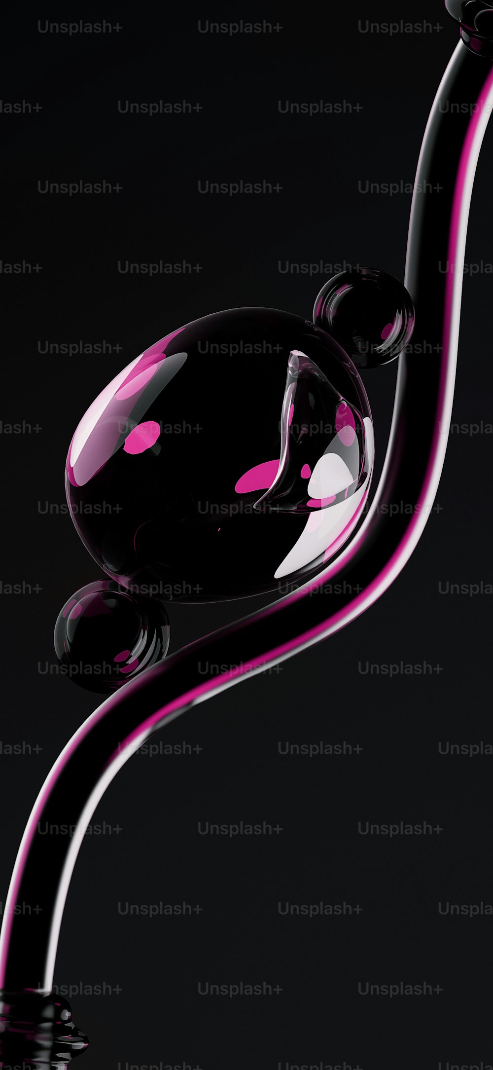 um objeto de vidro preto e rosa em um fundo preto