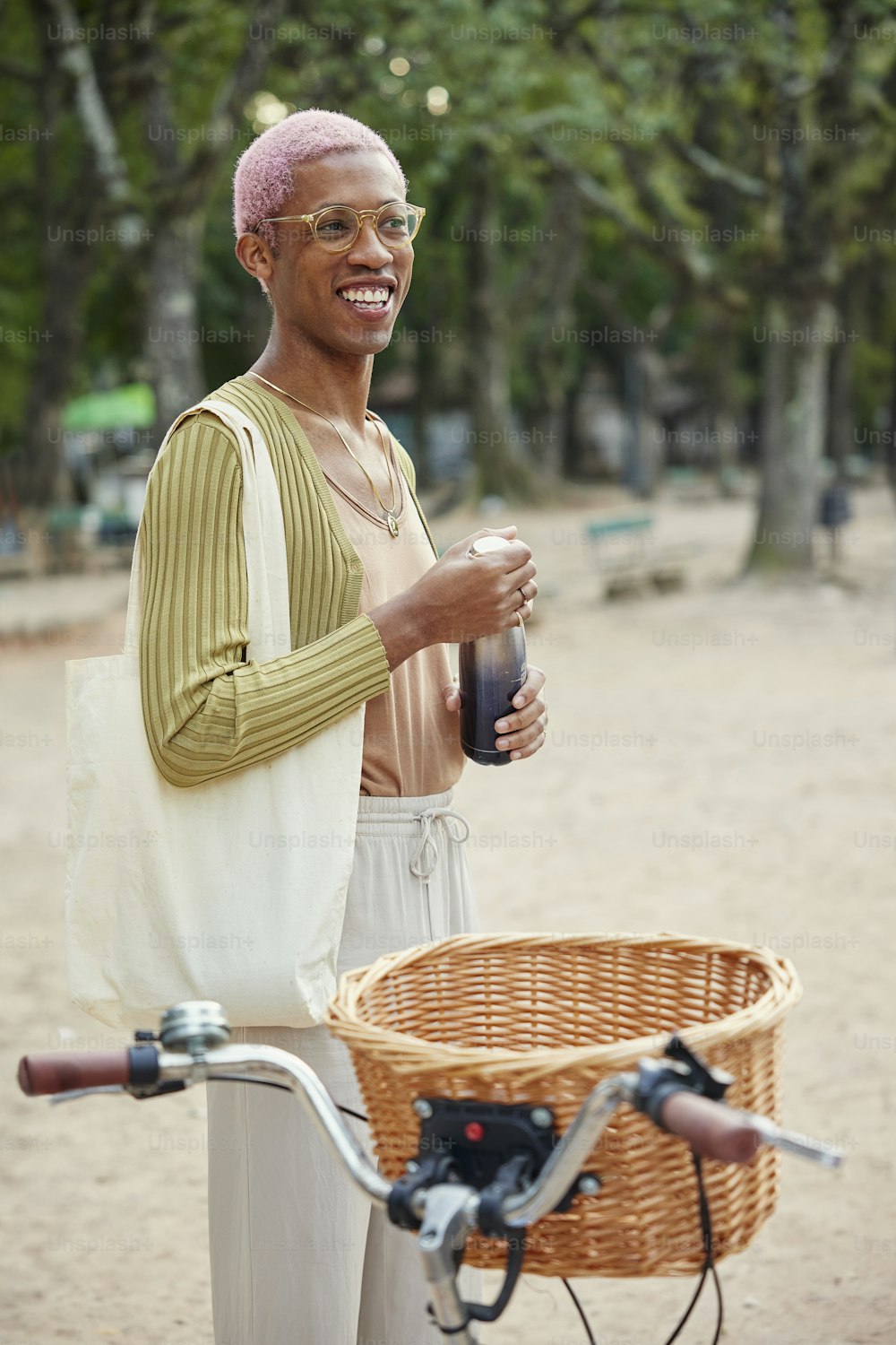 a man standing next to a bicycle holding a bottle