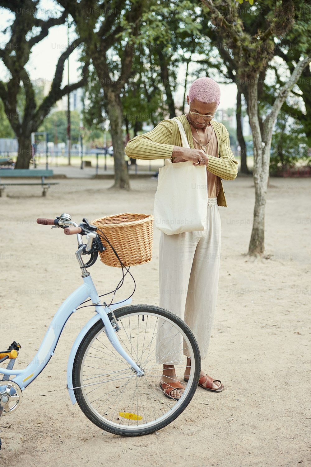 a woman standing next to a blue bicycle