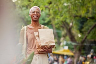 a man holding a brown paper bag and a brown paper bag