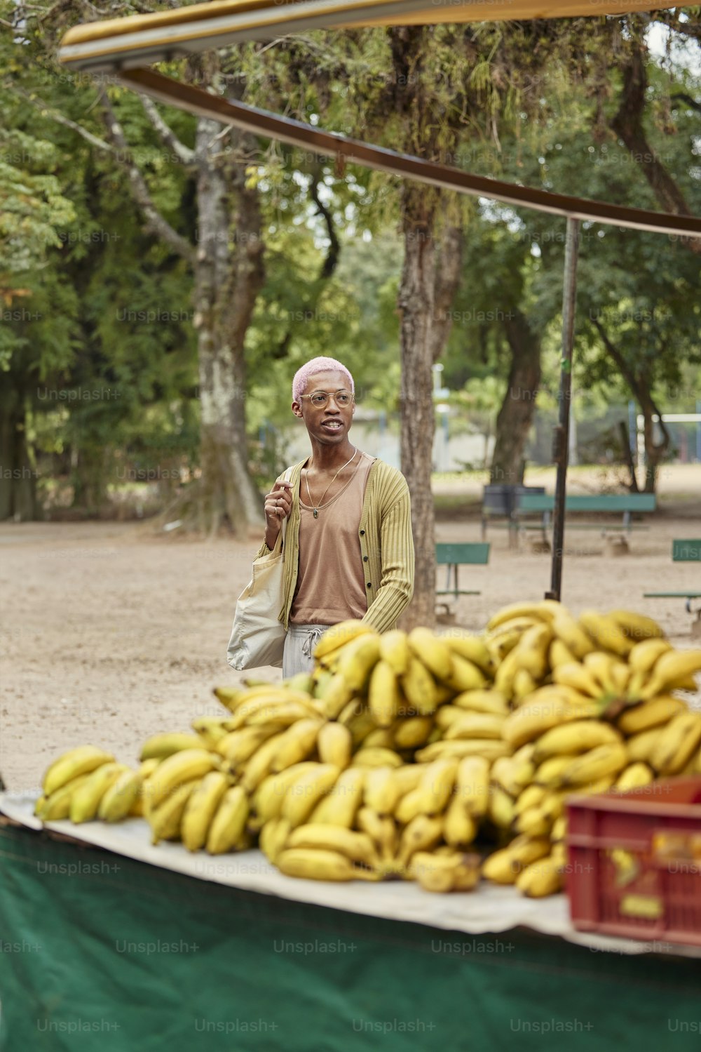 a man standing next to a pile of bananas