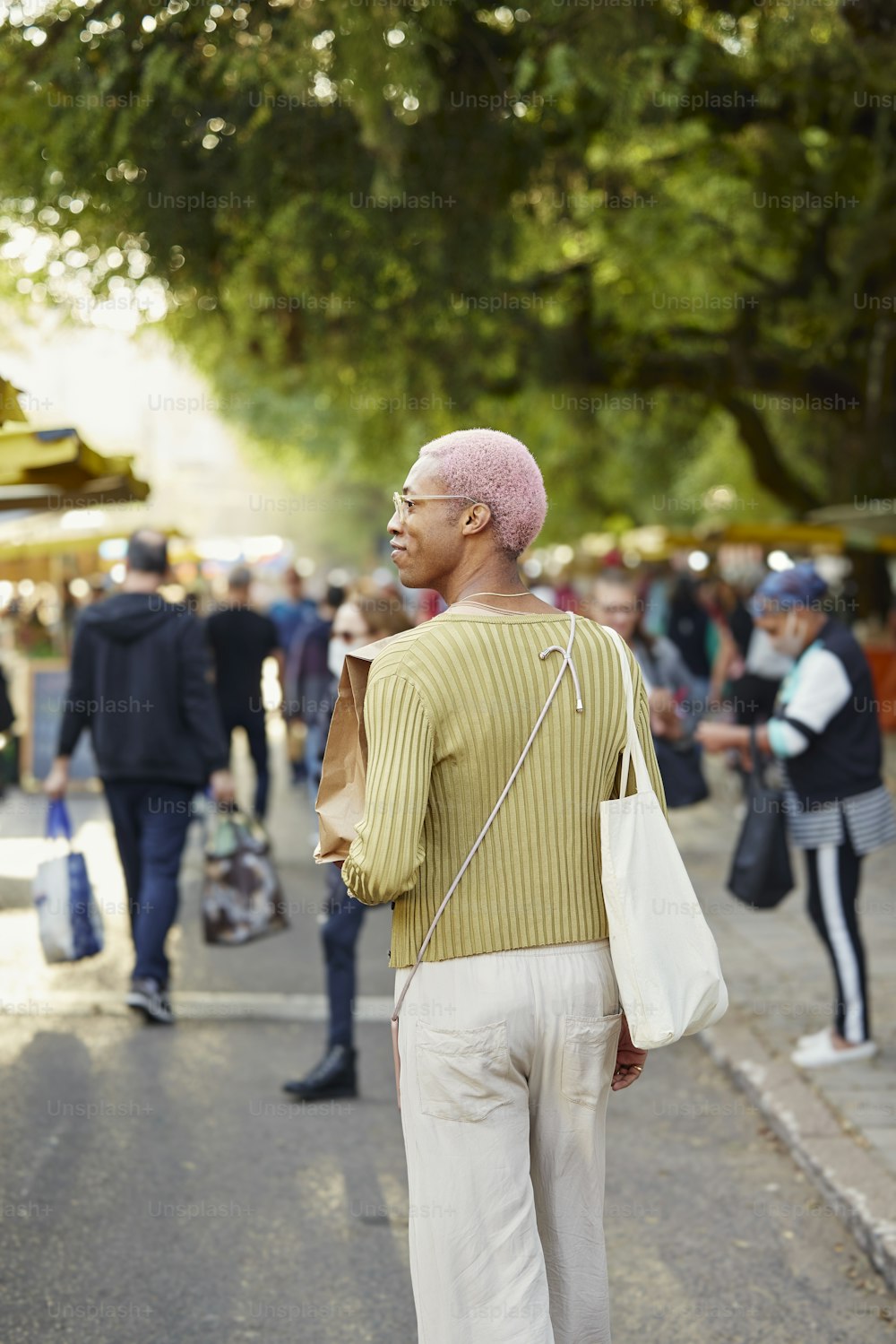 a man with a pink mohawk walking down a street