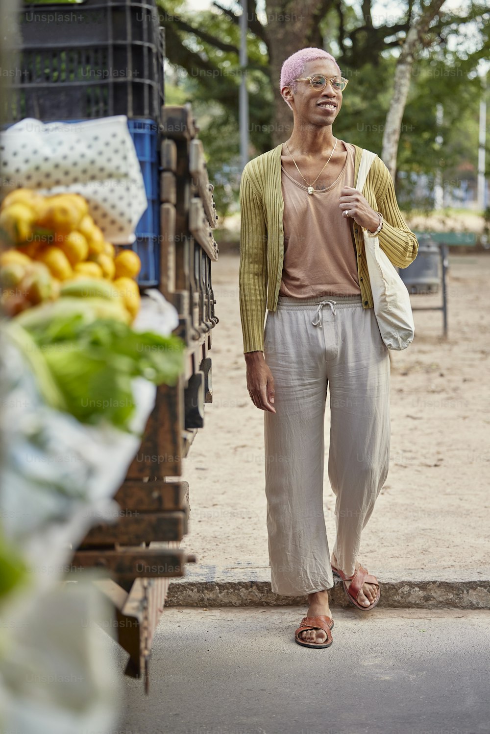 Una mujer parada frente a un puesto de frutas
