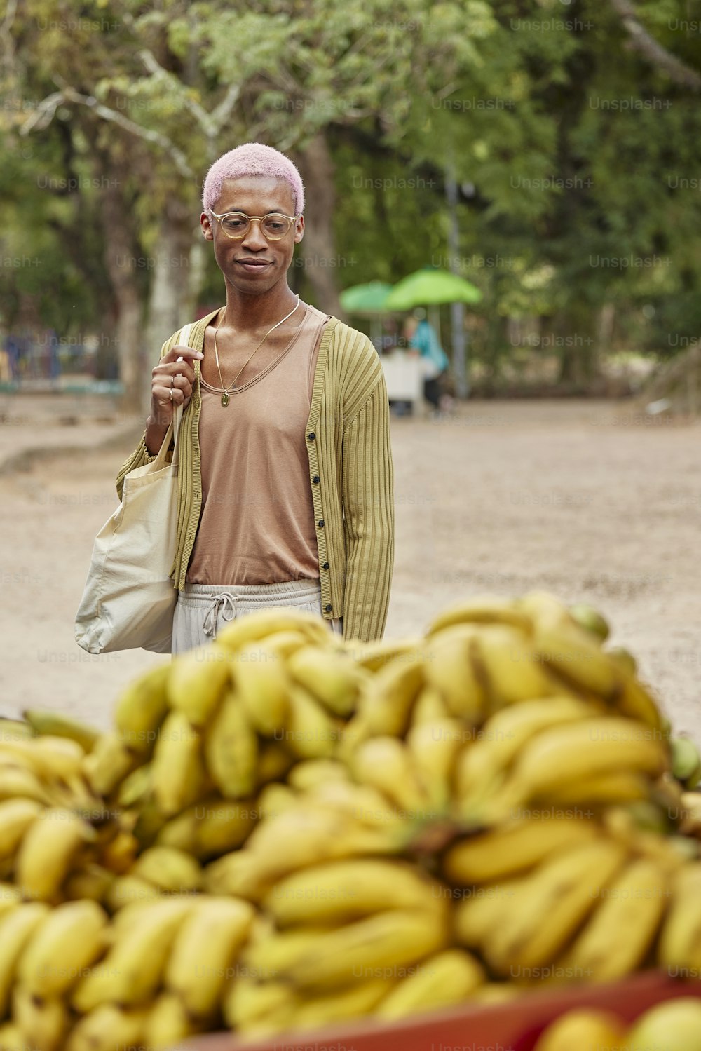 a man standing next to a pile of bananas
