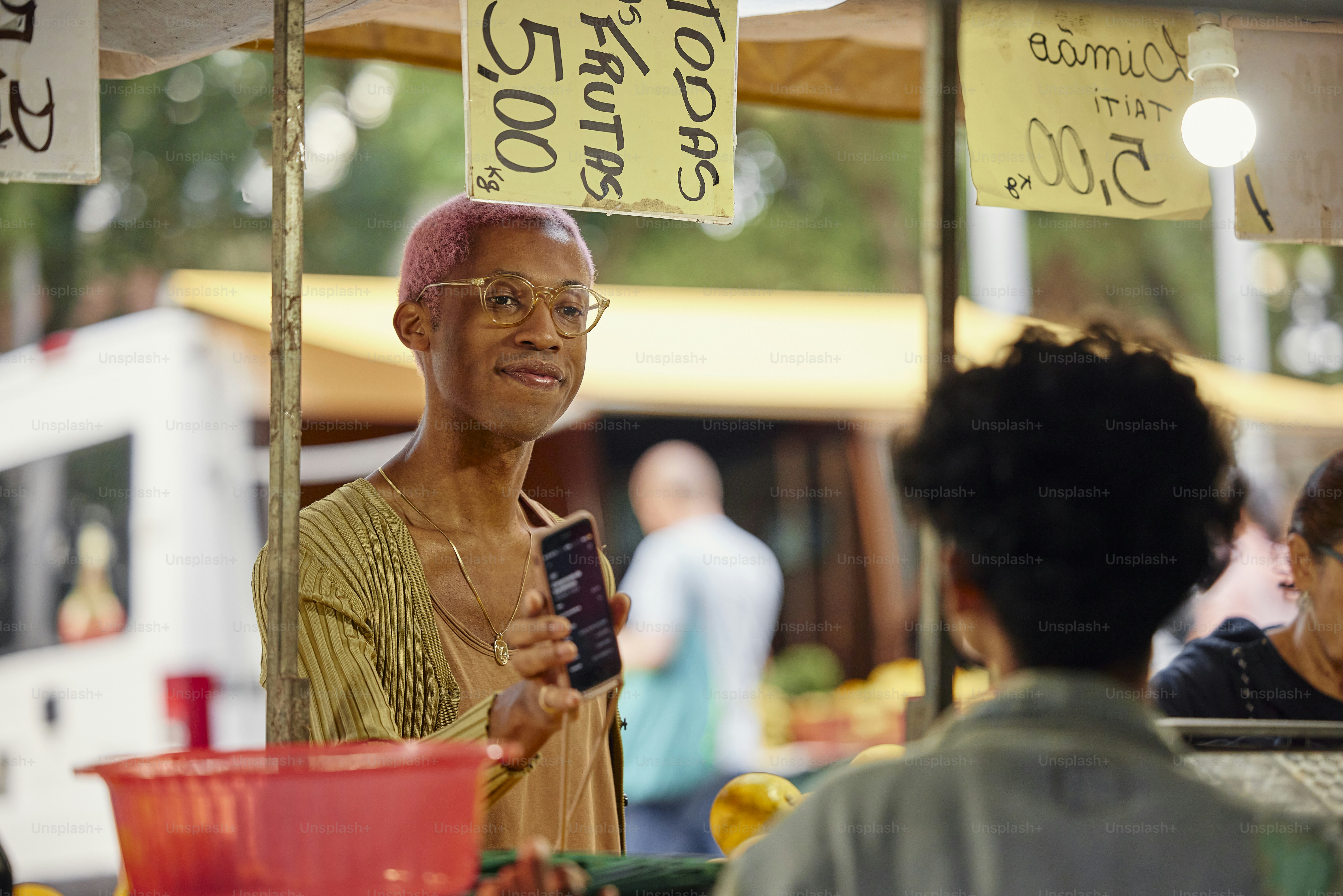 a woman with pink hair is holding a cell phone