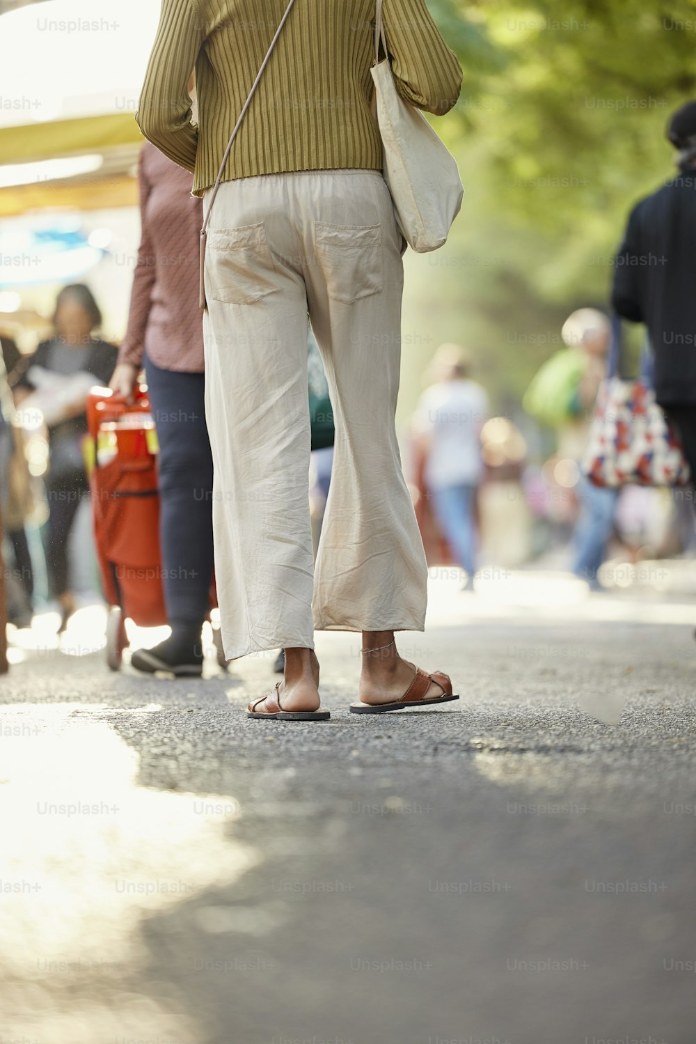 a woman walking down a street holding an umbrella