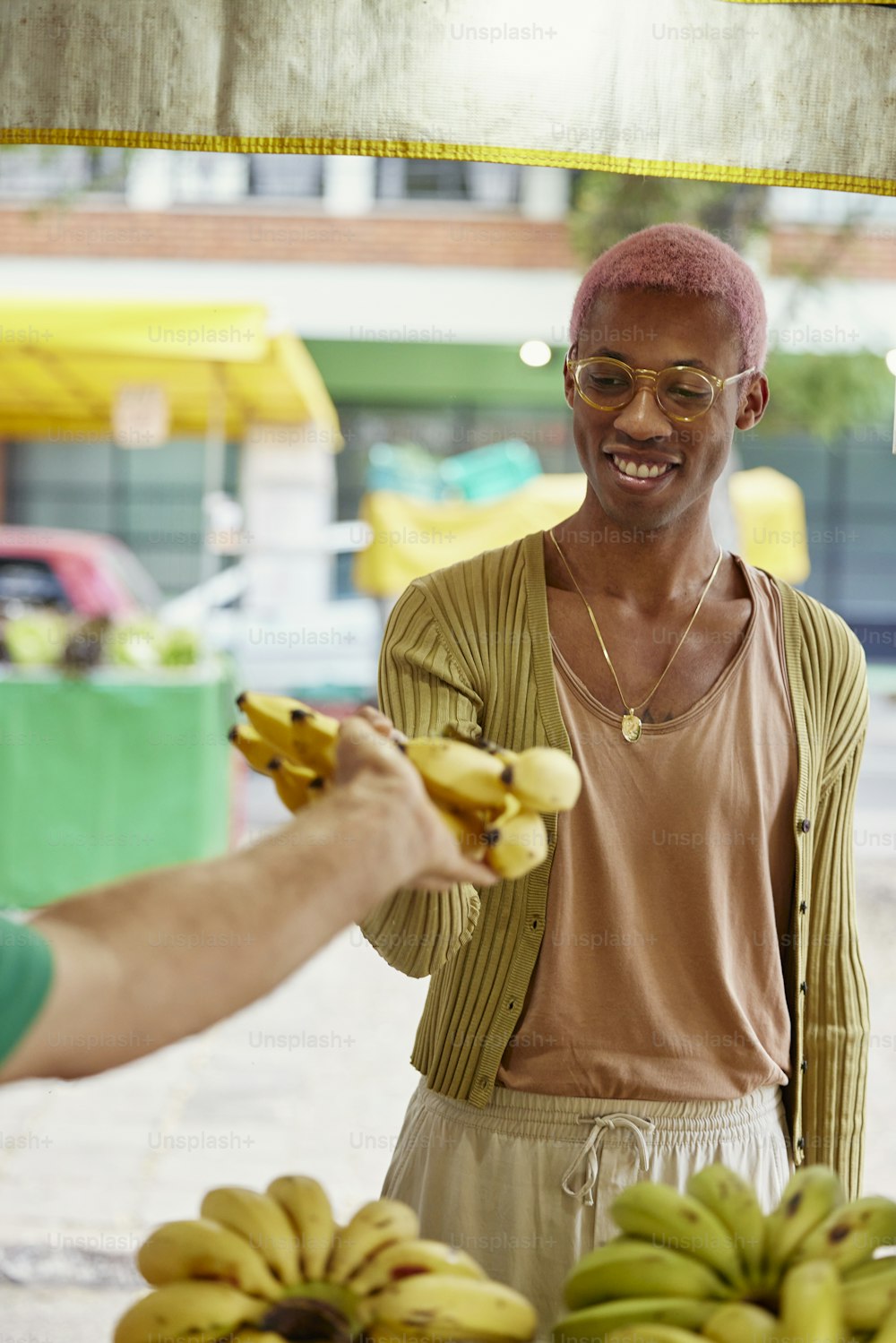 Un hombre sosteniendo un manojo de plátanos junto a otro hombre