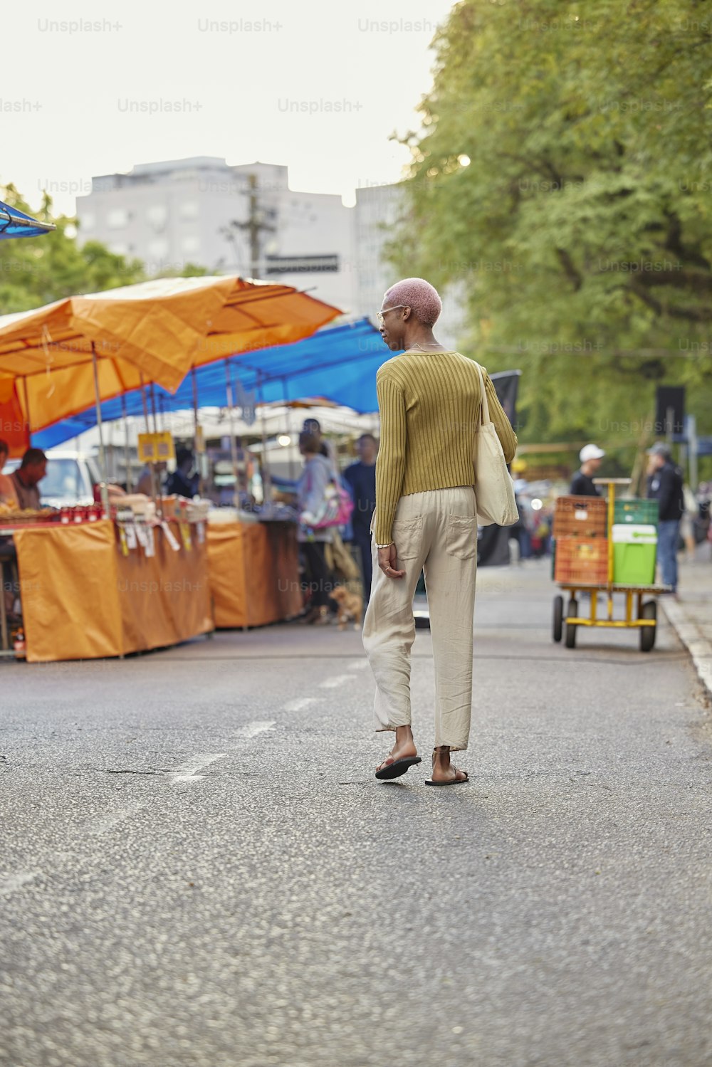 a man walking down a street next to tents