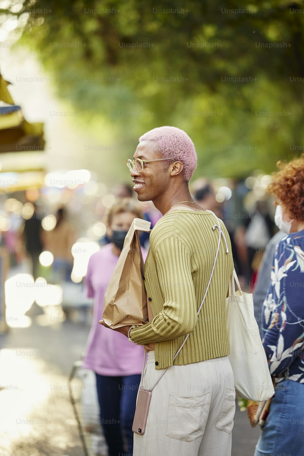 um homem com um moicano rosa parado em uma rua