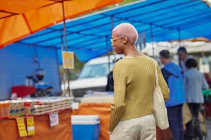 a man with a bald head standing in front of a tent