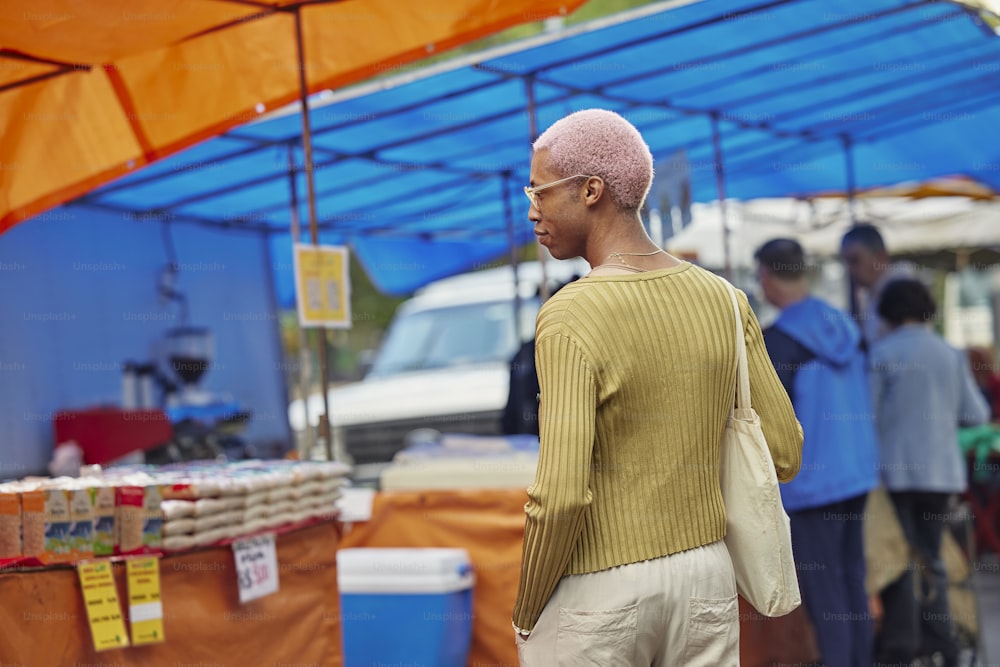 um homem com a cabeça careca em frente a uma tenda