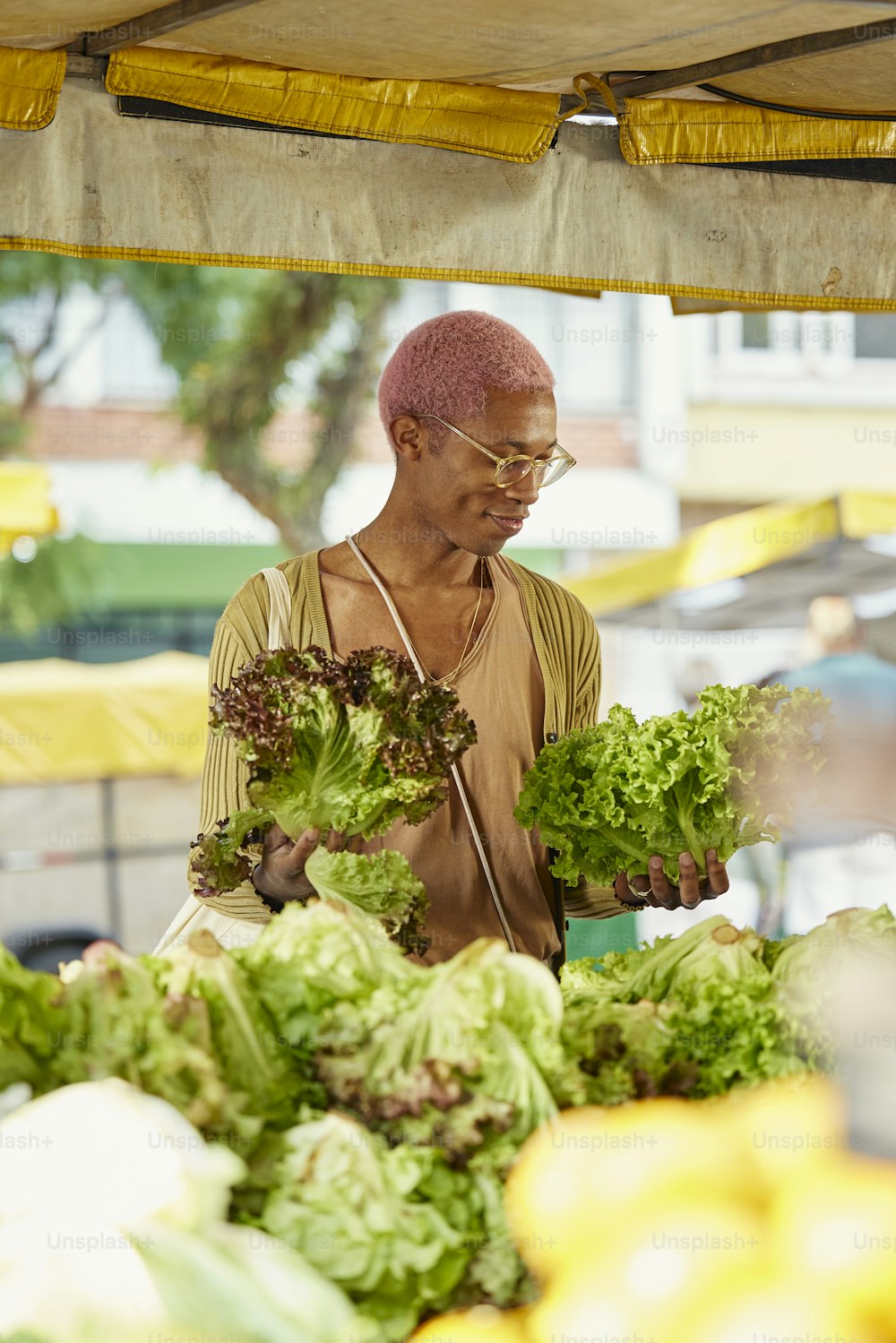 a man standing in front of a table filled with lettuce
