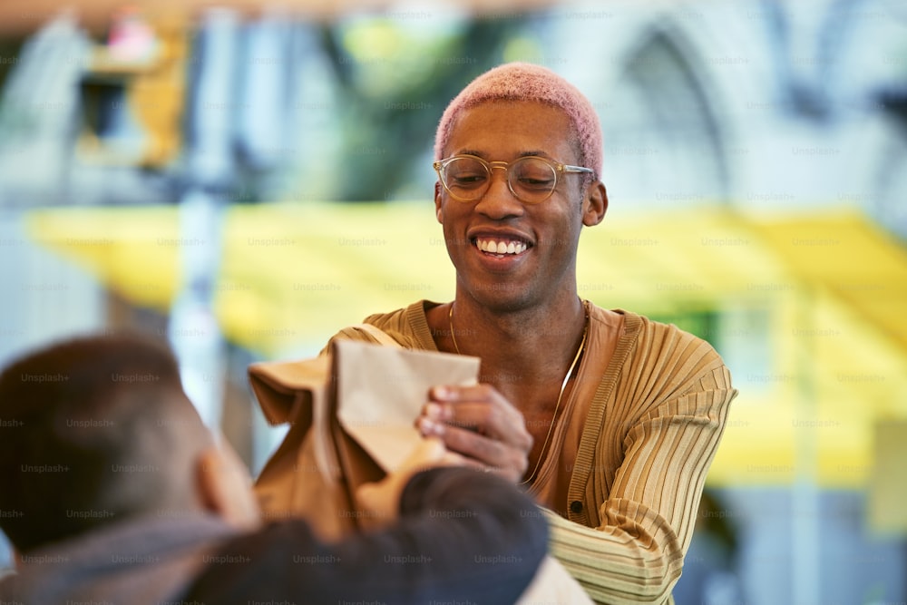 Un homme souriant en tenant un morceau de papier