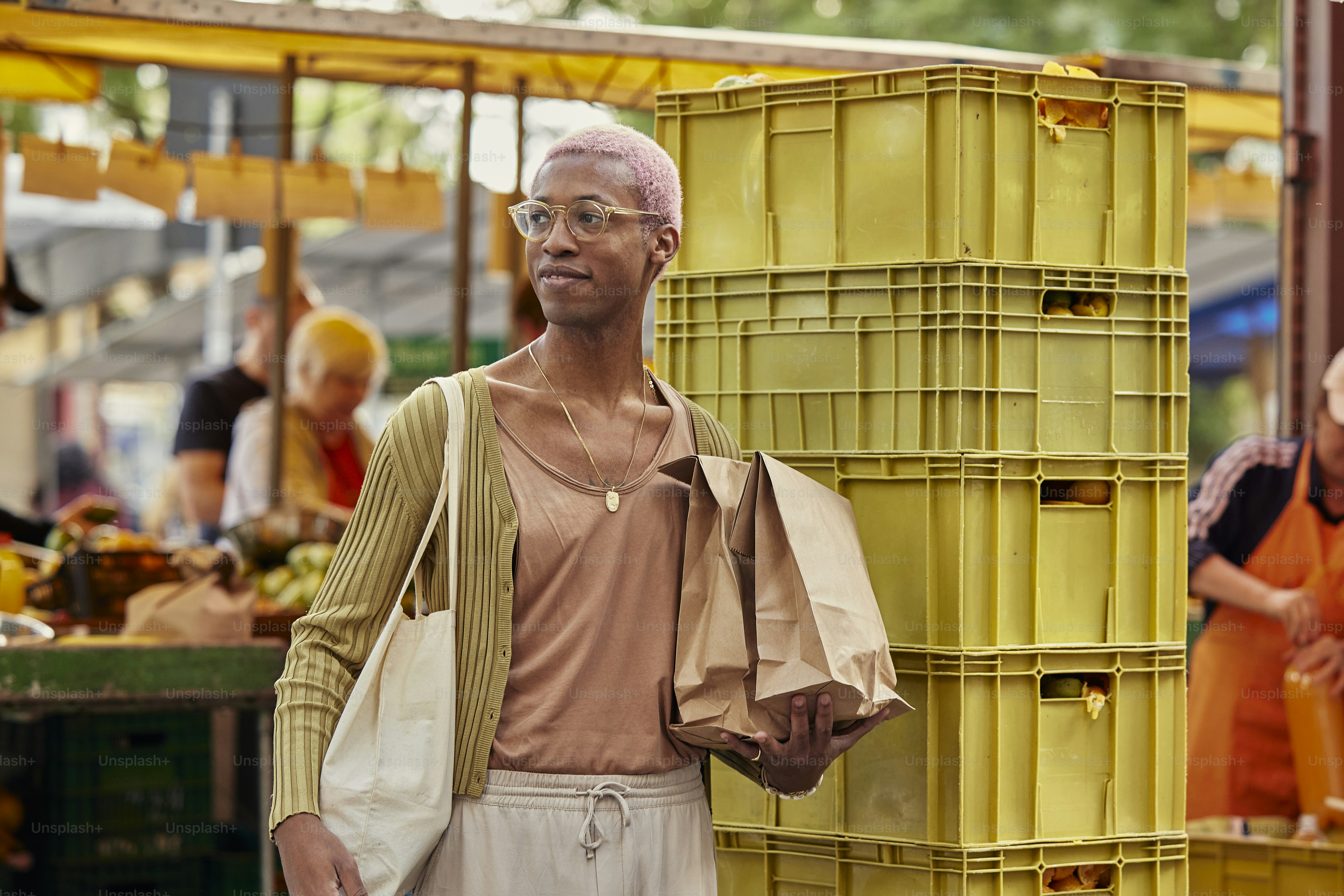 A person with pink hair at an outdoor market.