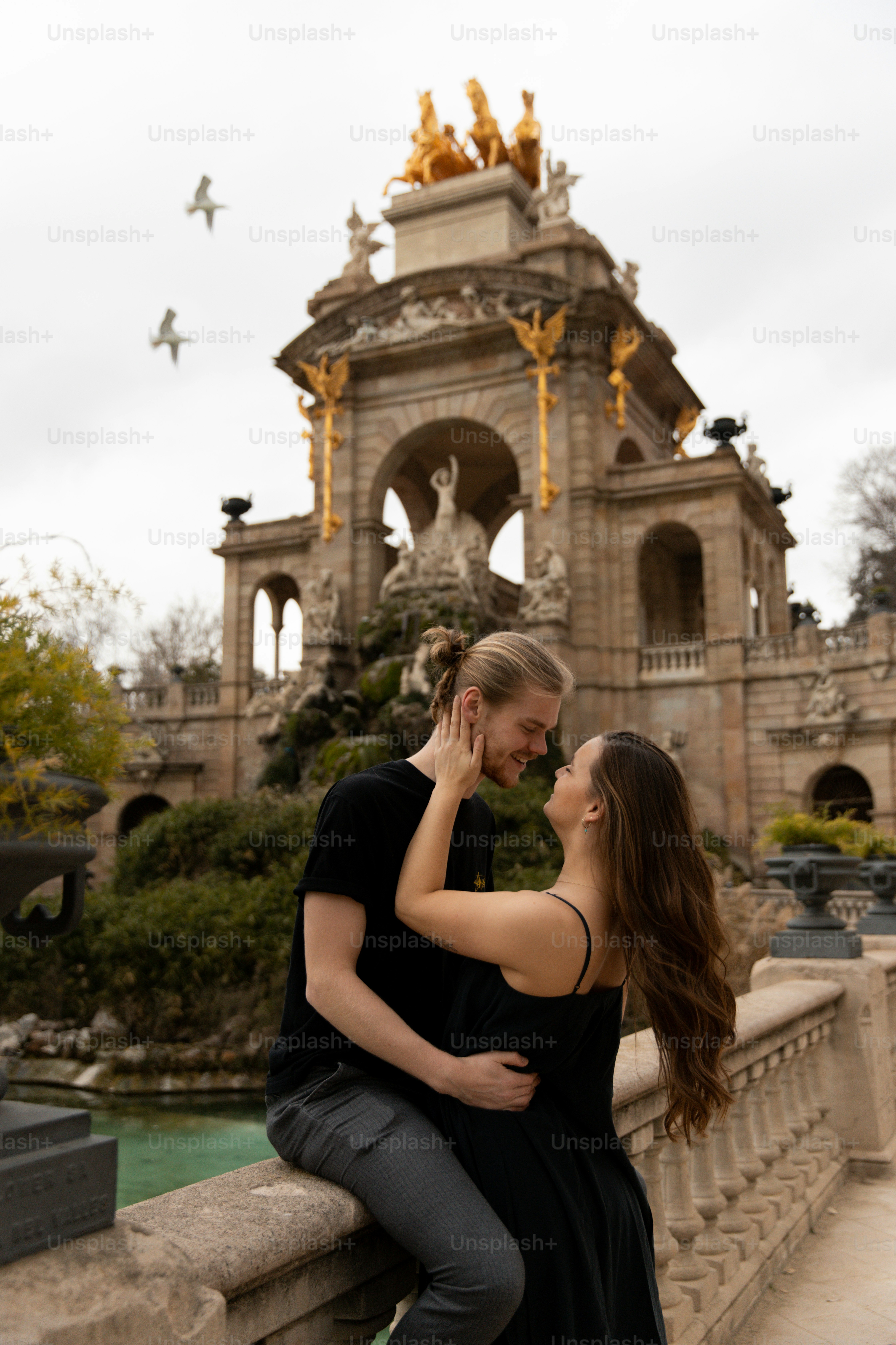 a man and a woman standing next to each other on a bridge